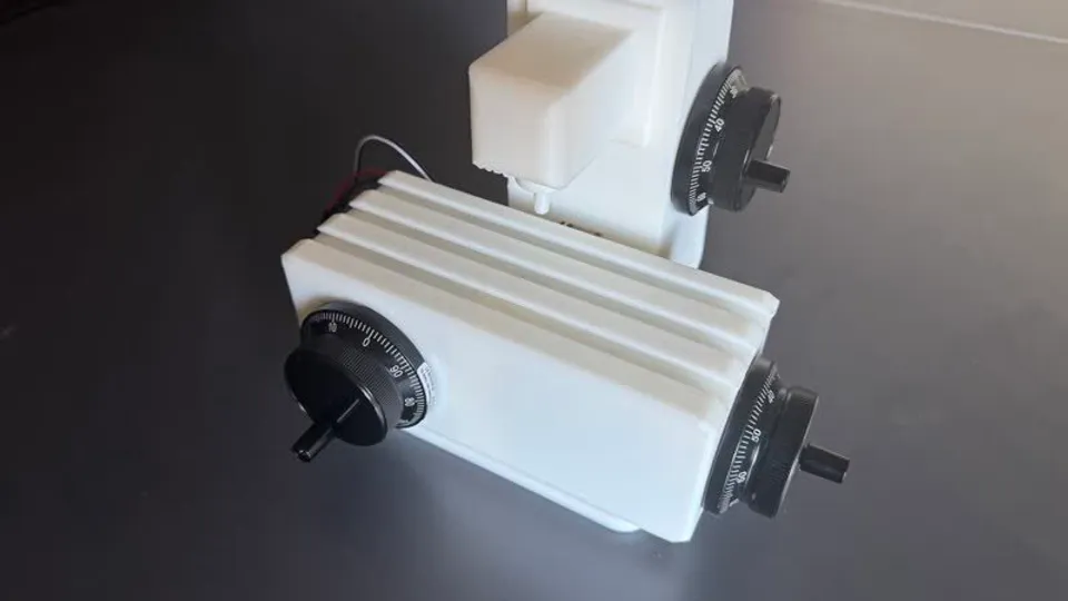 Close view of the T-slot table and the handwheels mounted on each axis